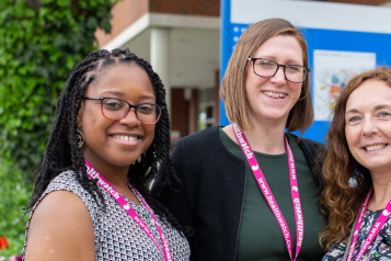 Three female staff members standing together outside a hospital entrance