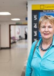 Woman standing in a hospital corridor in front of a sign